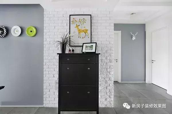 进门正面靠墙的鞋柜,纯黑色设计配上白色的文化石墙砖和彩色卡通装饰